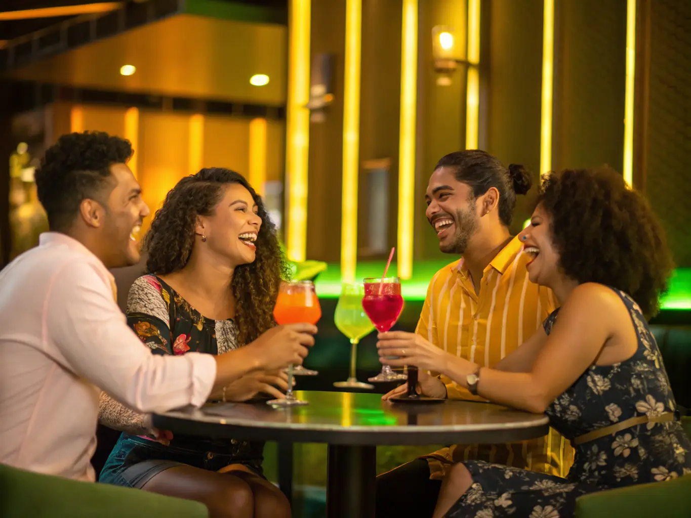 A group of friends laughing and enjoying drinks at a pub during the St. Patrick's Day Pub Crawl on a Saturday afternoon in San Francisco.